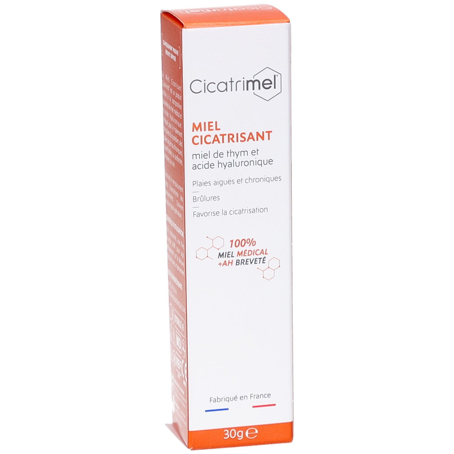 Emballage produit. Boîte blanche avec couvercle orange. Texte: Miel Cicatrisant, 30g. Logo et informations.