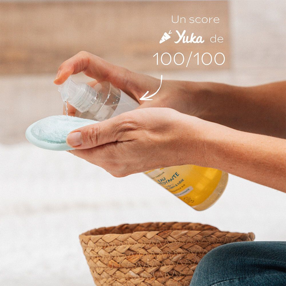 Mains avec WELEDA Baby Eau Nettoyante et lingette. Le produit est vaporisé sur la lingette. Score Yuka 100/100.