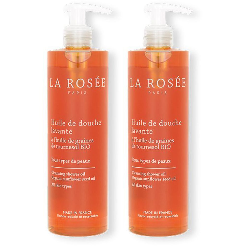 Deux flacons de La Rosée Huile de douche lavante. Liquide orangé dans des flacons transparents avec pompes blanches. Texte visible.