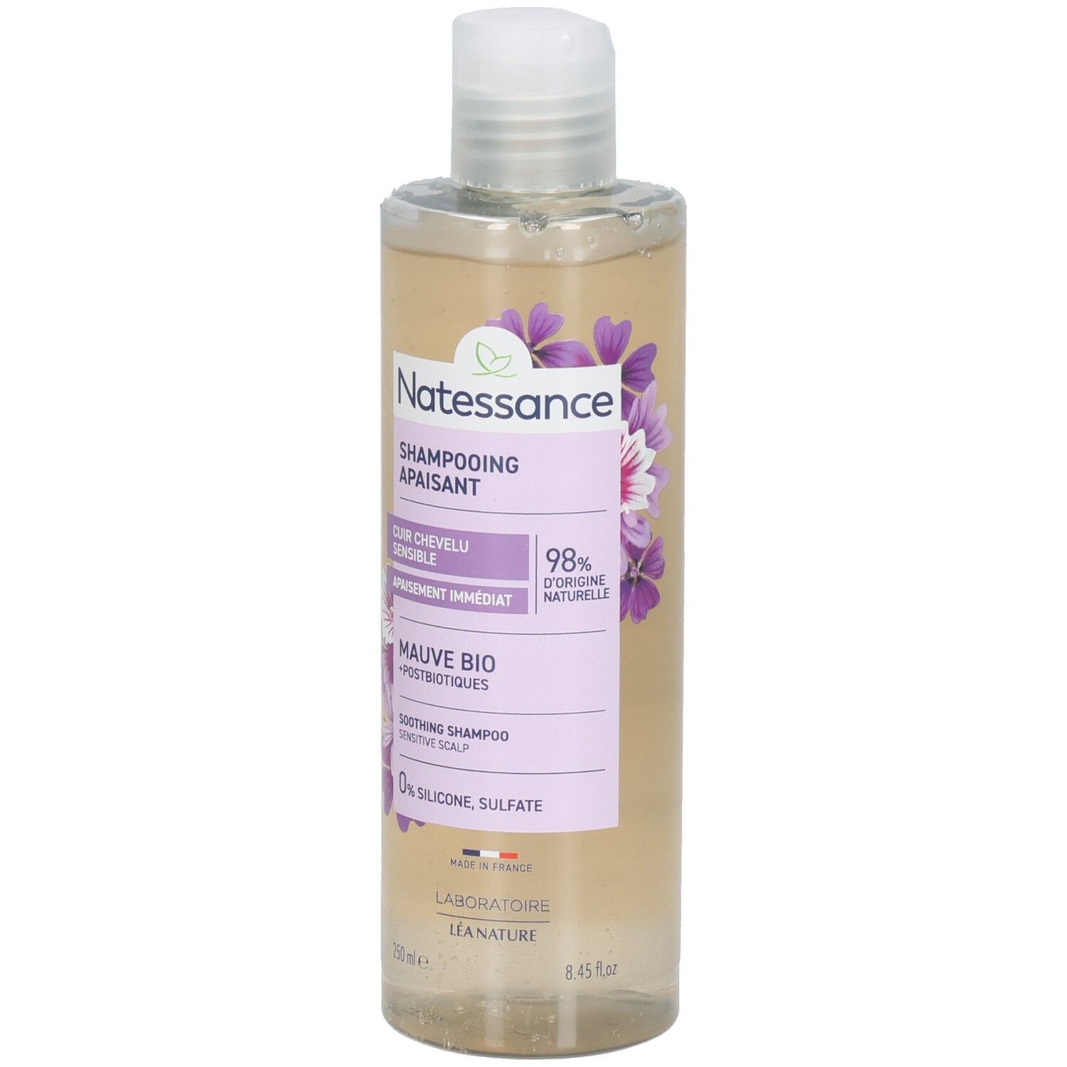 Flacon de shampooing Natessance Apaisant, Cuir Chevelu Sensible. Étiquette lilas avec fleurs. Bouchon blanc.