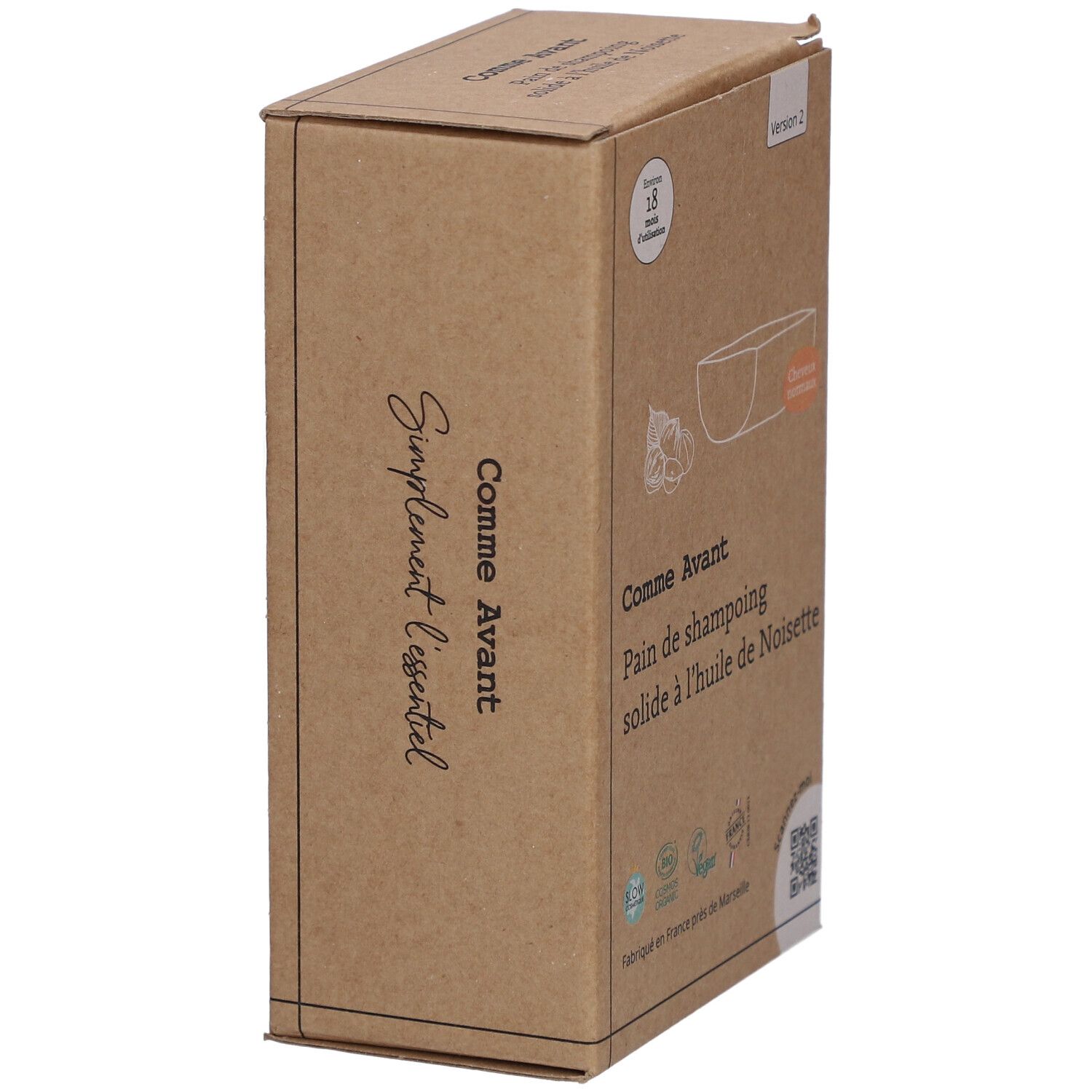 Boîte en carton, en biais. Inscription: Comme Avant, Pain de shampoing solide à l'huile de Noisette. Avec illustration et texte.
