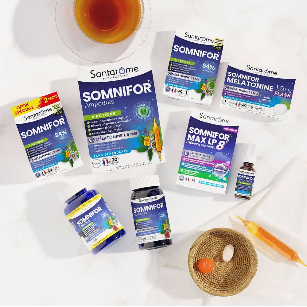 Différents produits Santarome Somnifor. Ampoules, gélules, comprimés. Sur une table. Avec une tasse de thé et un bol.