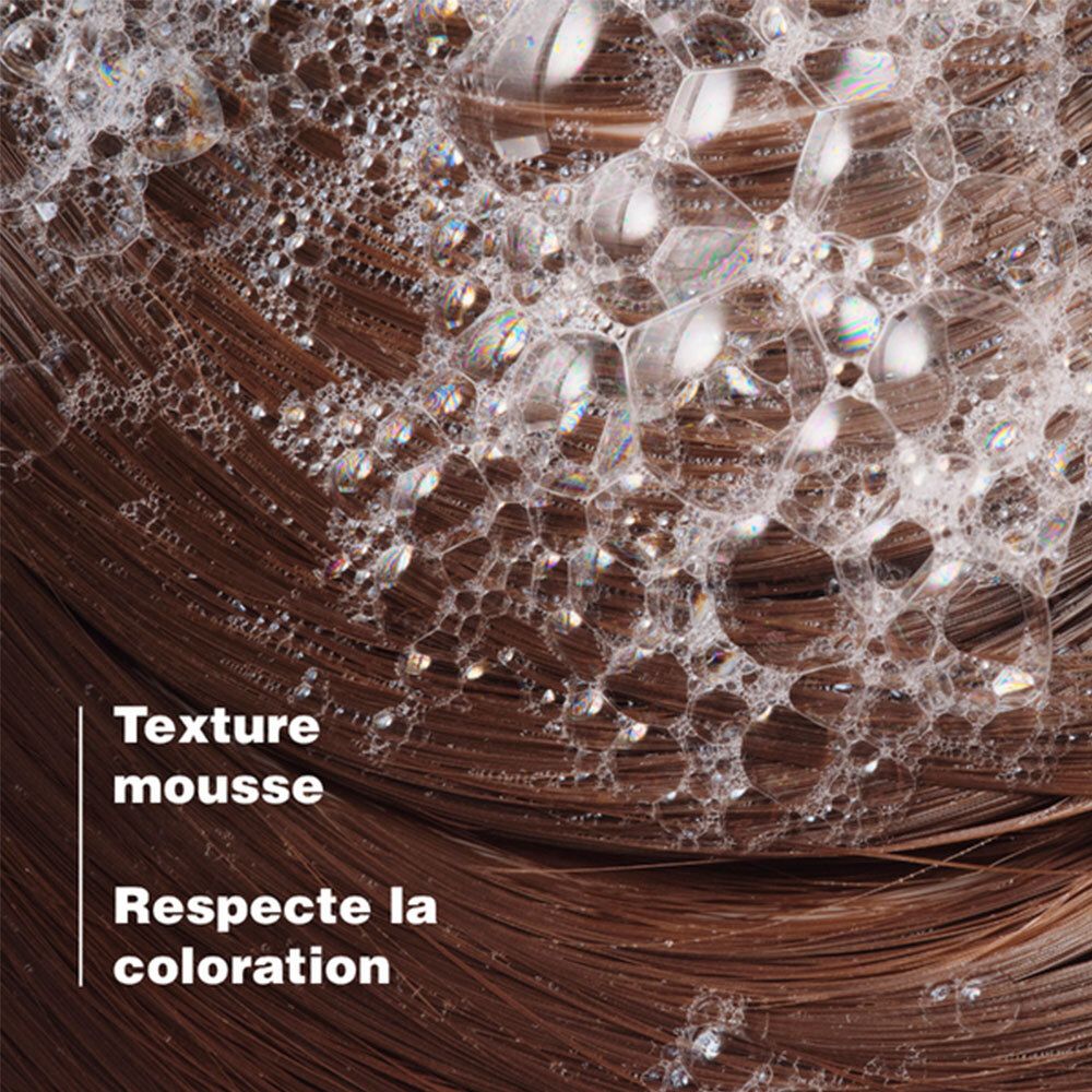Gros plan sur cheveux bruns avec mousse. Texte: Texture mousse. Respecte la coloration.