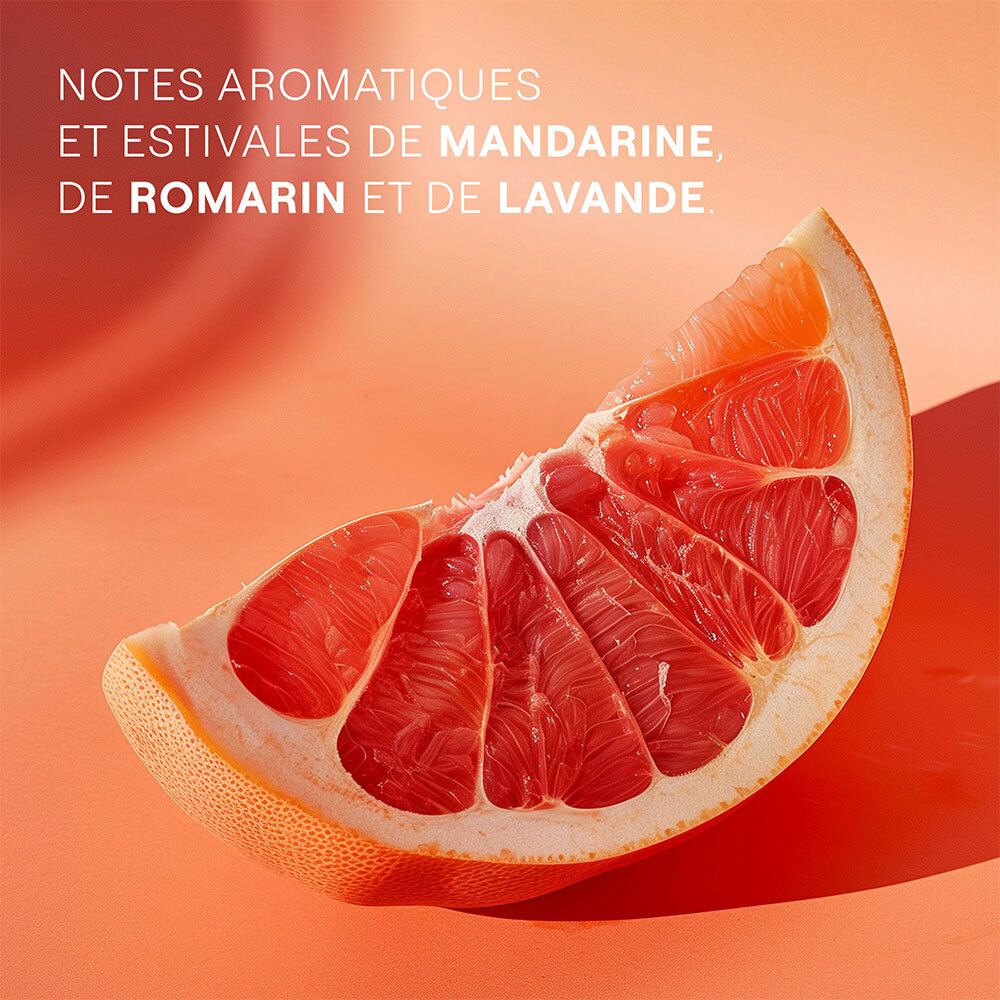 Moitié de pamplemousse coupé sur fond orange. Structure du fruit visible. Texte : "NOTES AROMATIQUES ET ESTIVALES DE MANDARINE, DE ROMARIN ET DE LAVANDE."