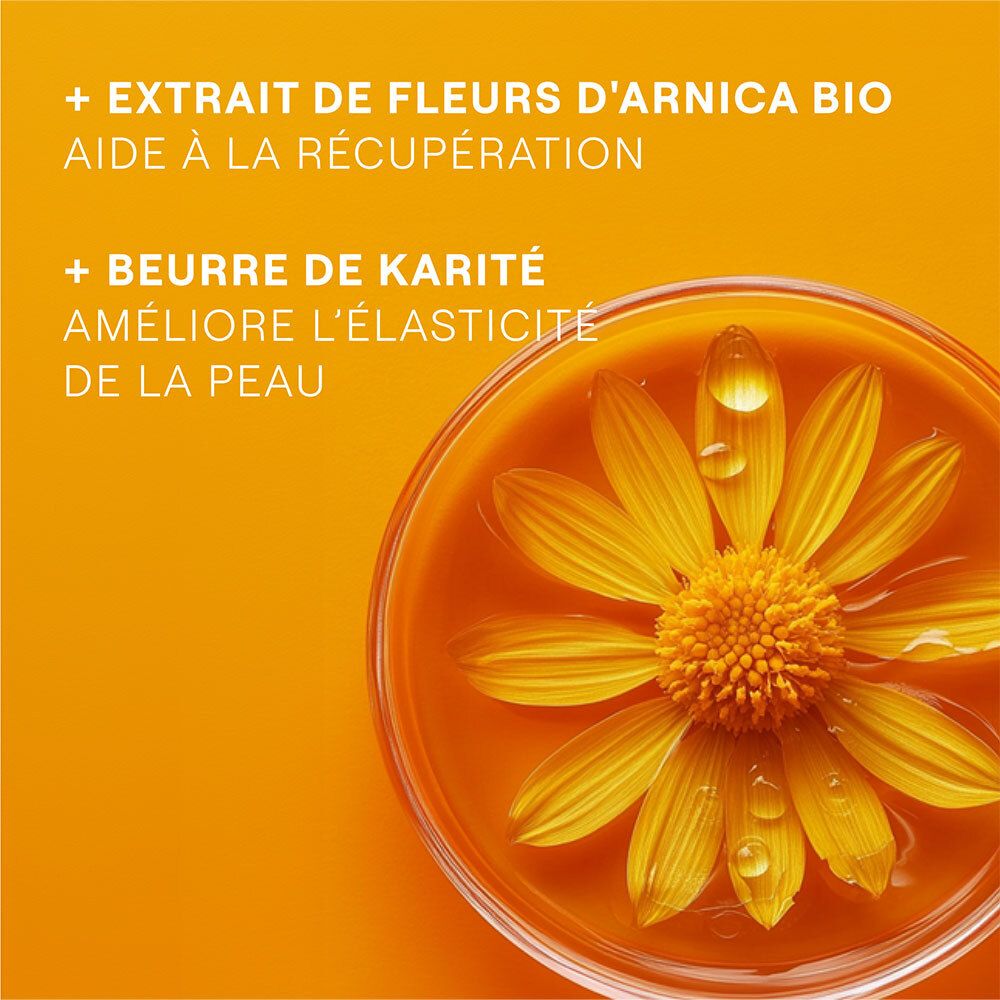 Gros plan de fleurs jaunes dans un liquide. Texte: + Extrait de Fleurs d'Arnica Bio, + Beurre de Karité.