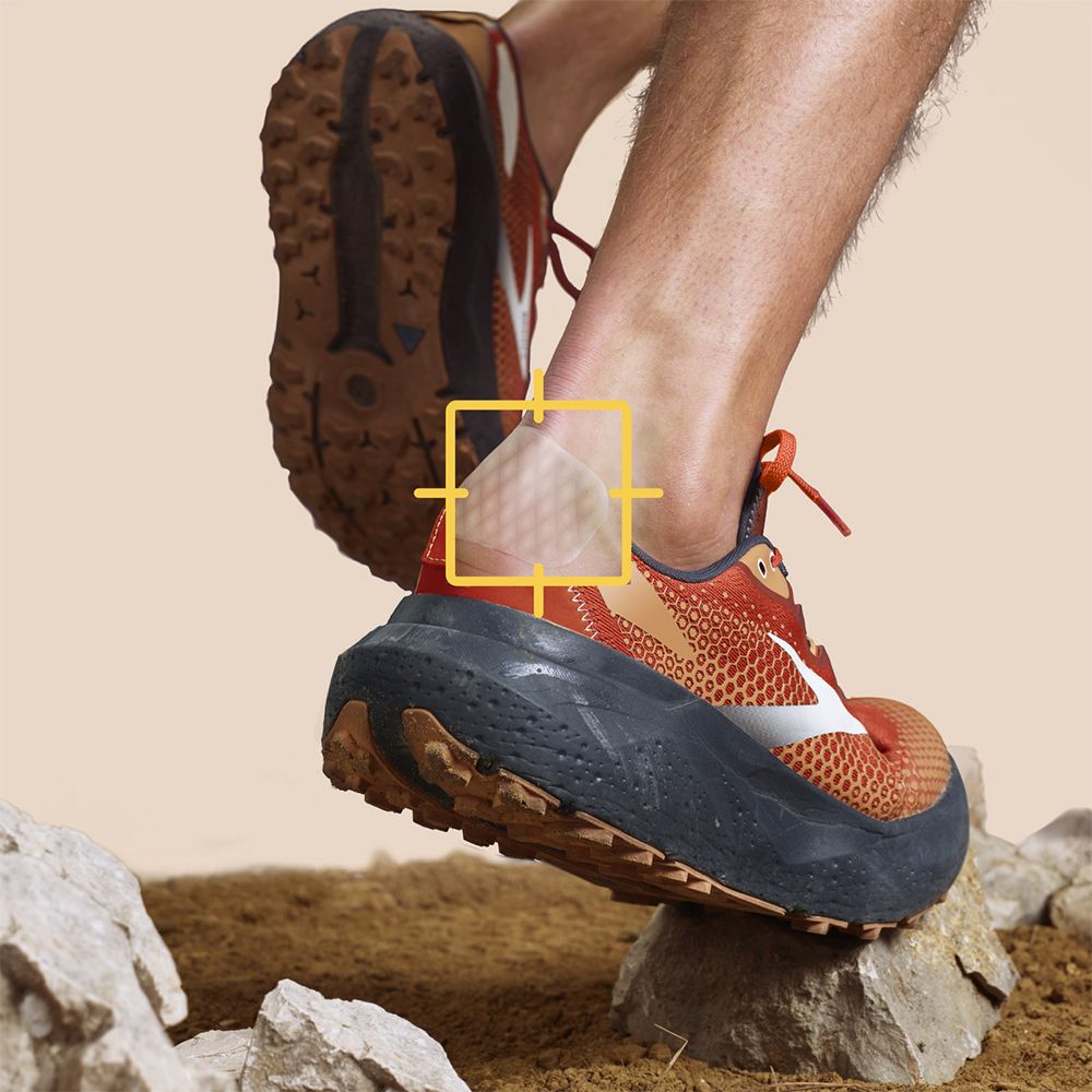 Pied avec pansement, porté dans une chaussure de sport. Pansement sur le talon. Fond avec pierres et terre.