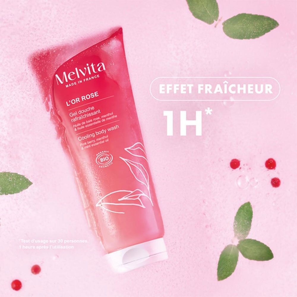 Tube de gel douche rose Melvita. Texte: L'OR ROSE, Gel douche rafraîchissant. Certification bio. Fond avec feuilles et baies.