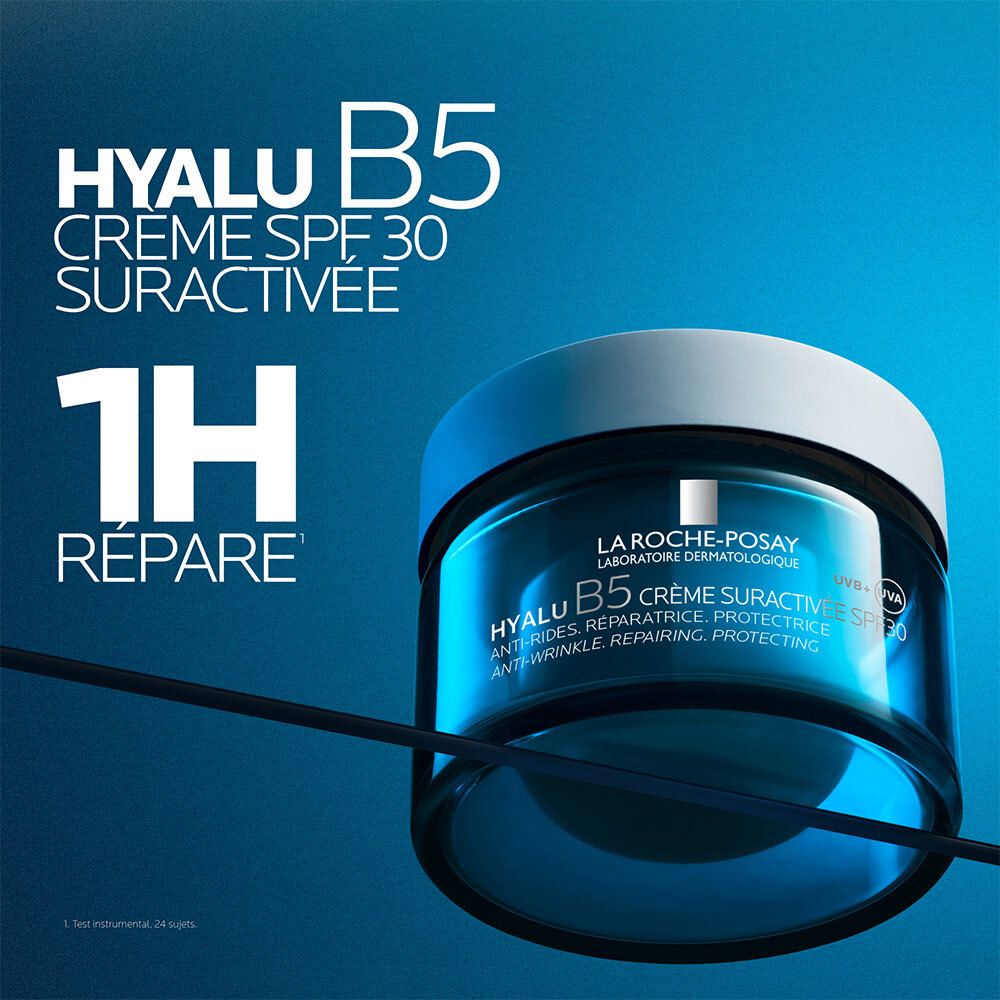 Pot de crème bleu avec couvercle blanc. Texte: HYALU B5 Crème SPF30 Suractivée. 1H Répare. Sur fond bleu.