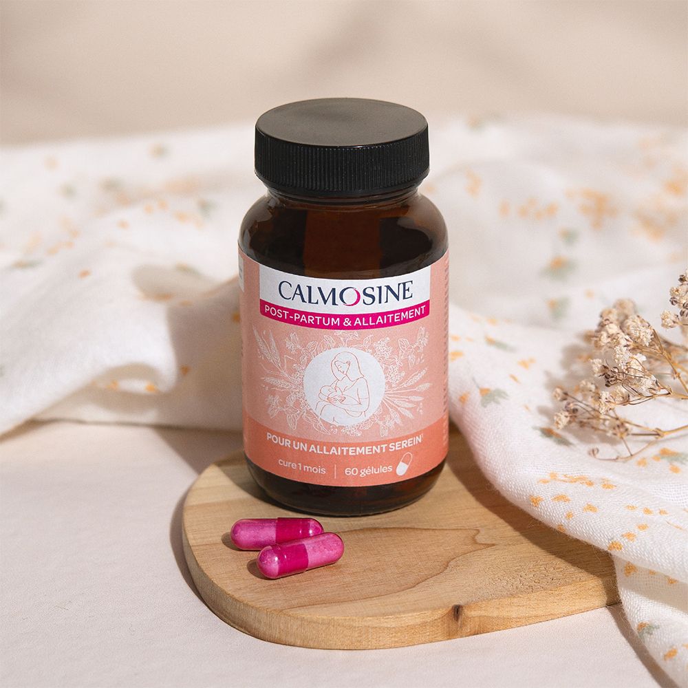 Flacon en verre brun, bouchon noir. Étiquette rose avec nom du produit et capsules. Deux gélules roses à côté.