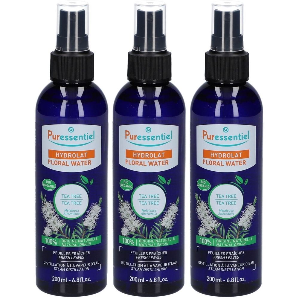 Trois flacons pulvérisateurs bleus avec bouchon noir. Inscription: Puressentiel, Hydrolat Floral Water, Tea Tree. Avec label bio.
