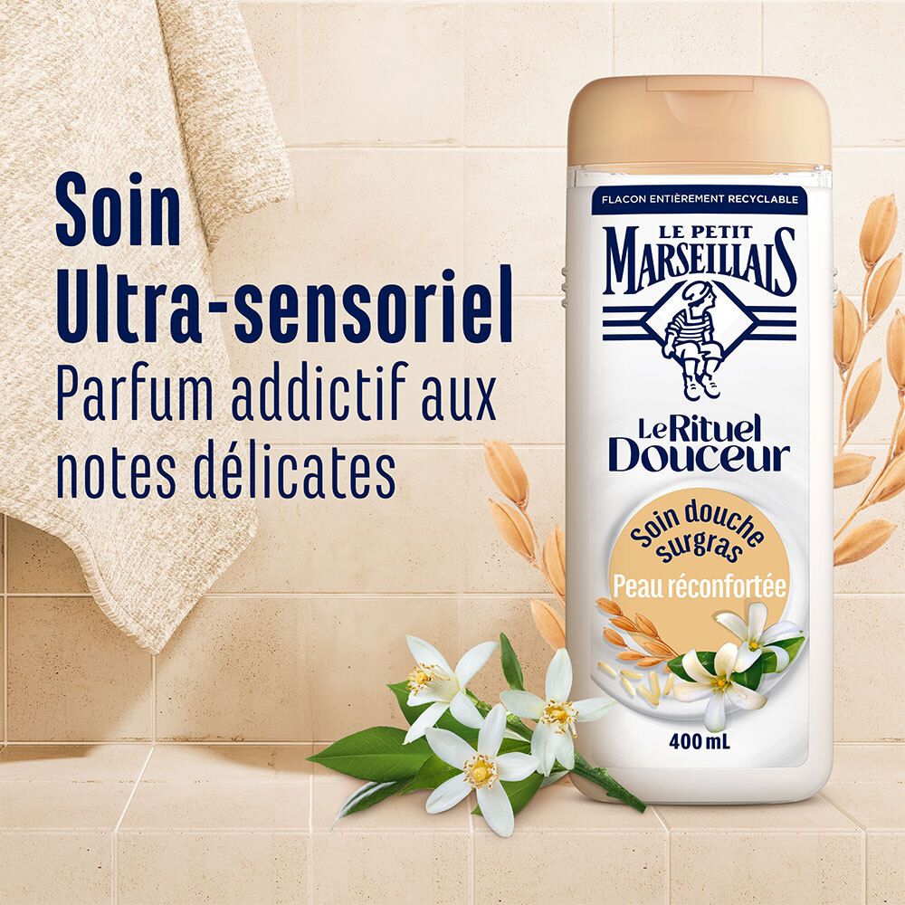 Flacon de produit près d'une serviette et de fleurs. Texte: Soin Ultra-sensoriel Parfum addictif aux notes délicates.