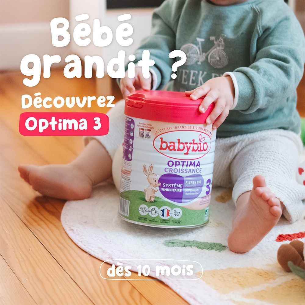 Un enfant assis avec une boîte Optima 3. Inscription : Optima 3, dès 10 mois.
