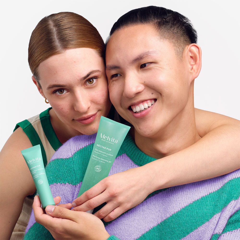 Deux personnes tiennent des tubes. Inscriptions : MELVITA, NECTAR PUR, Gel-crème correcteur matifiant, certification bio.