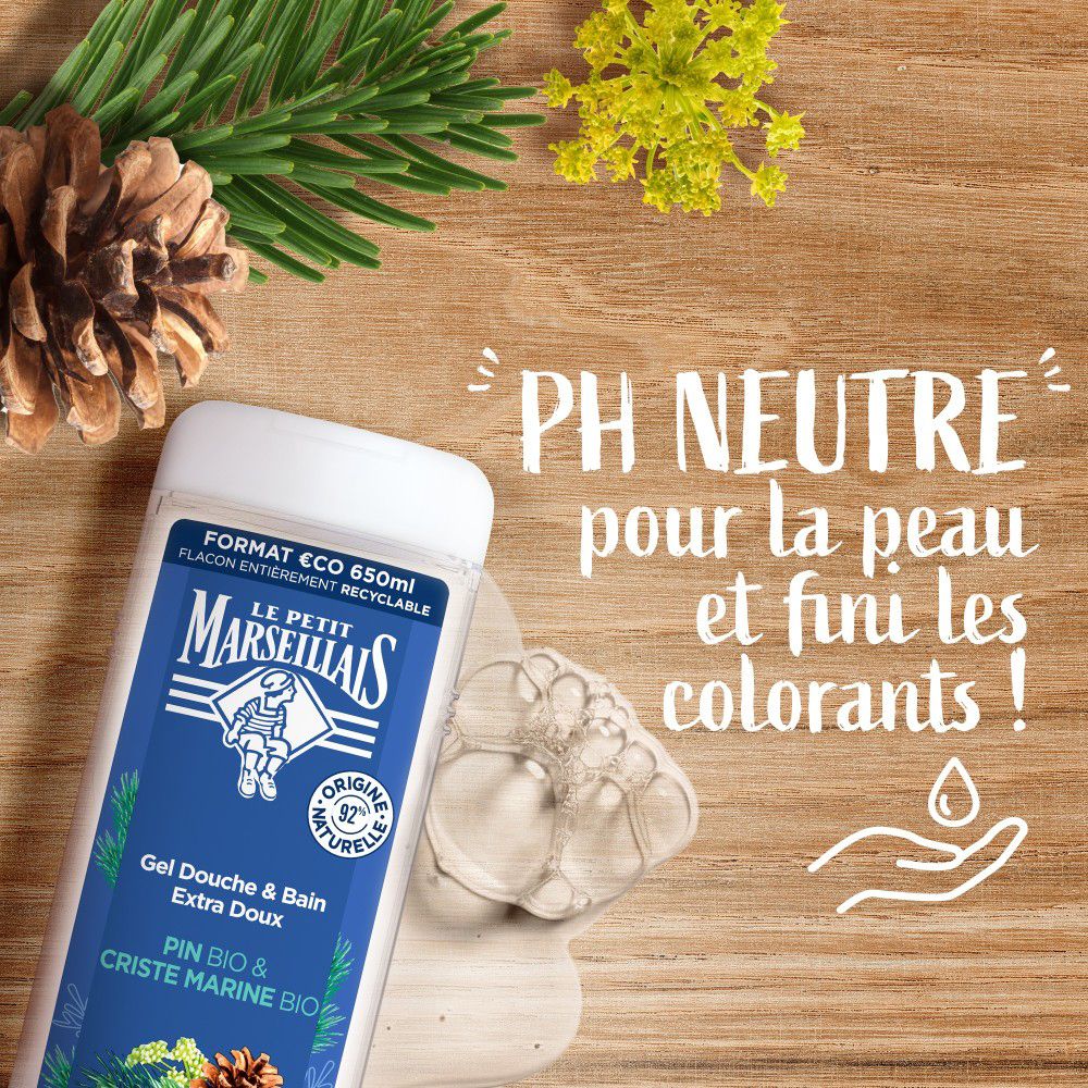 Flacon de produit à côté de branches de pin et de mousse. Texte: pH neutre pour la peau et fini les colorants !