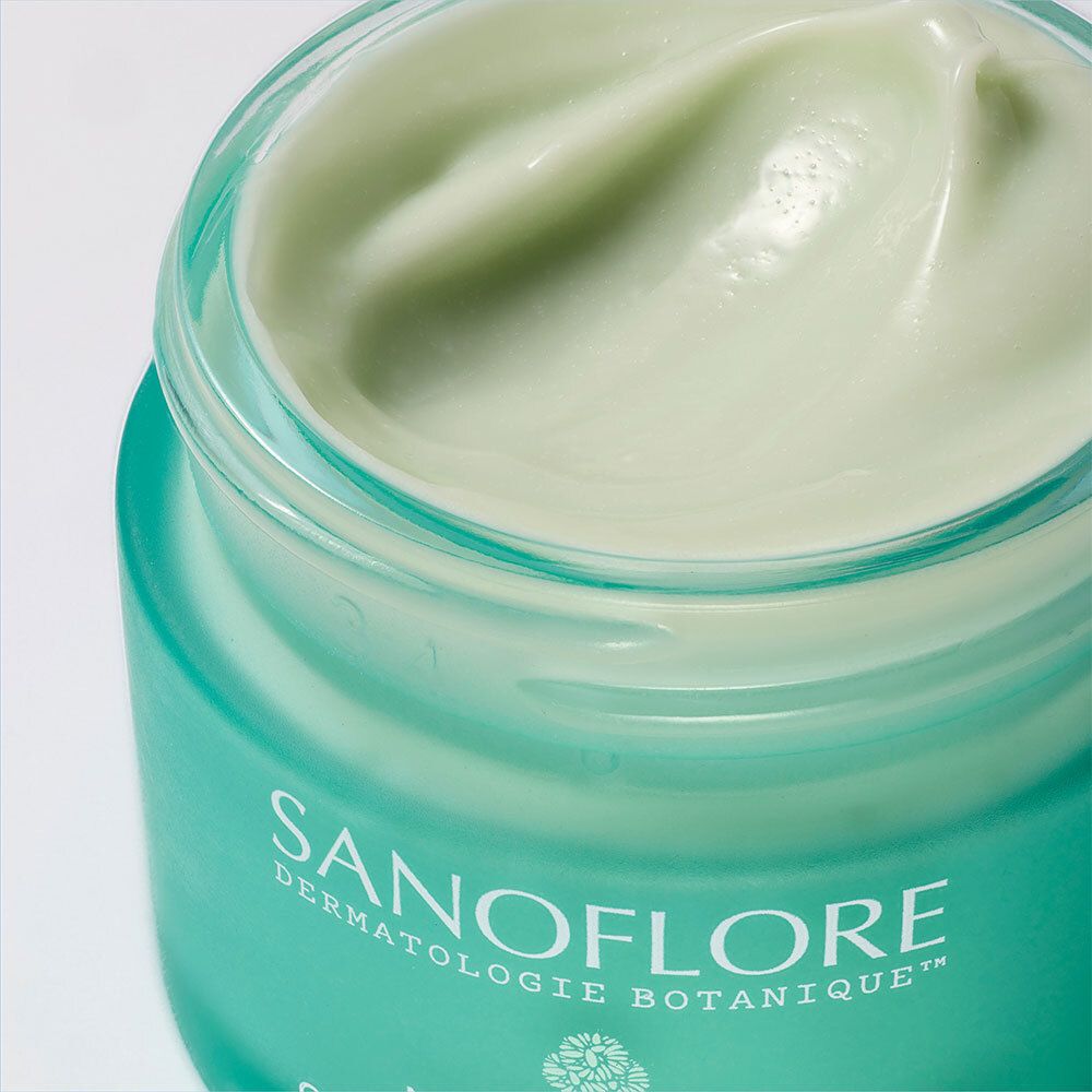 Gros plan du pot SANOFLORE Magnifica Crème Nuit Anti-Imperfections. Crème visible dans le pot. Texte: SANOFLORE.