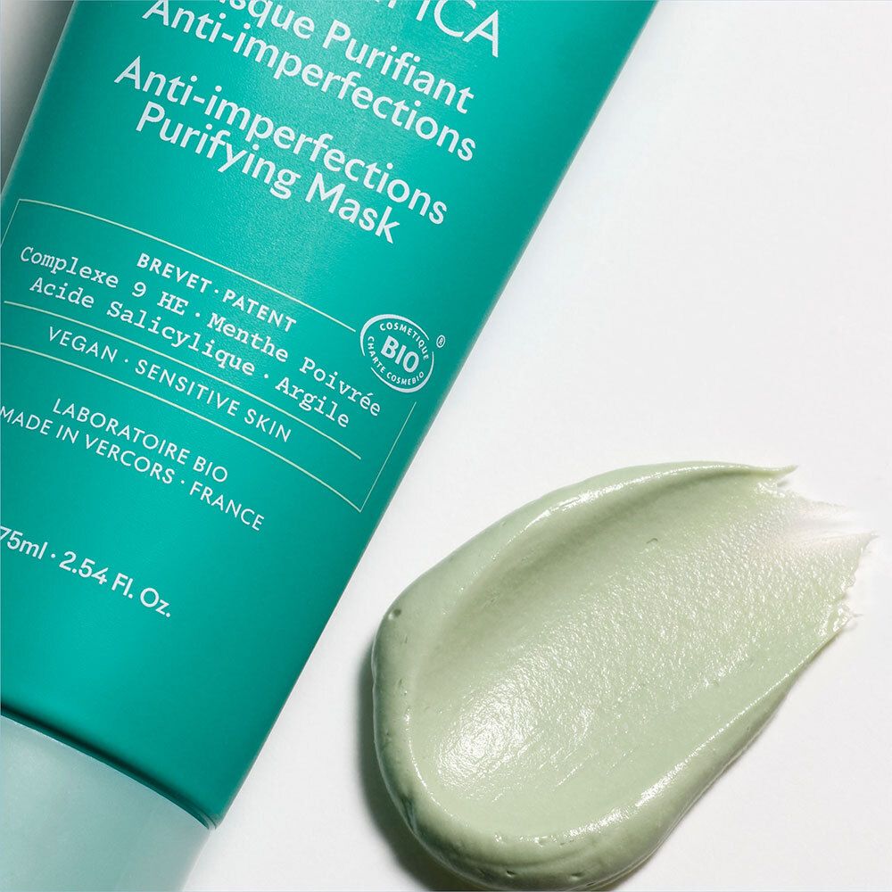 Éclaboussure de masque vert sur fond blanc. Inscription: Magnifica Masque Purifiant Anti-imperfections. Certification bio.
