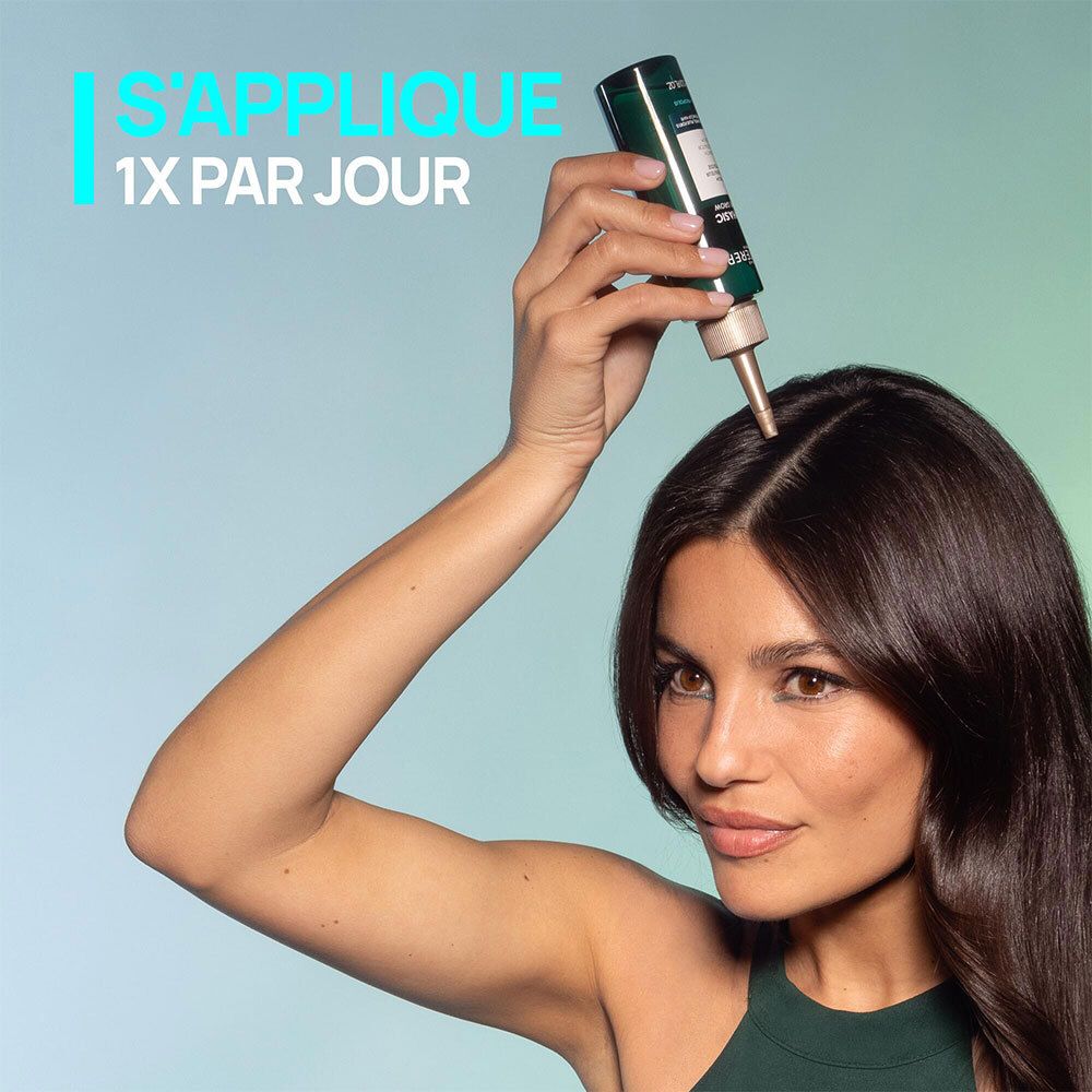 Femme appliquant le sérum sur le cuir chevelu. Texte: S'applique 1x par jour.