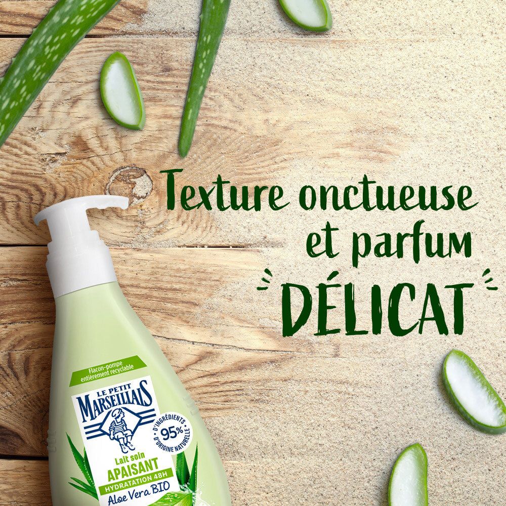 Lait soin Le Petit Marseillais sur fond bois avec tranches d'Aloe Vera.