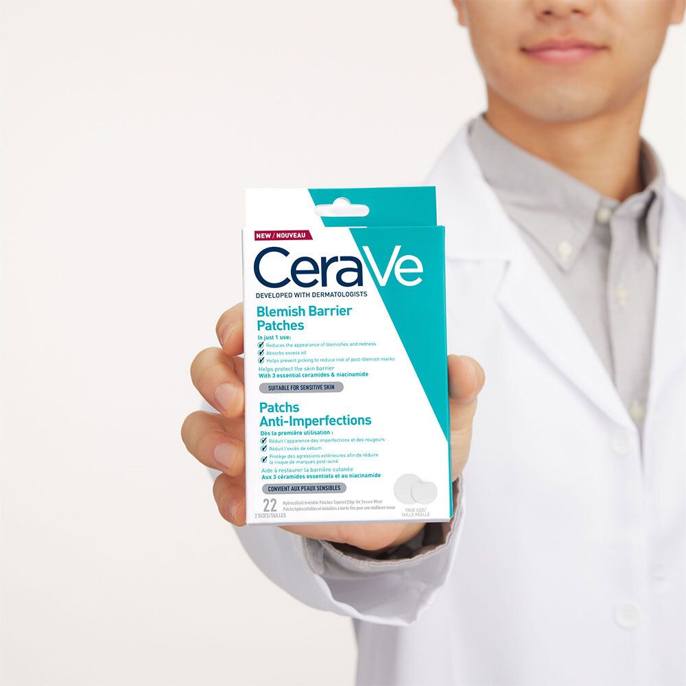 Personne tenant une boîte de patchs anti-imperfections CERAVE. Blouse blanche, chemise grise.