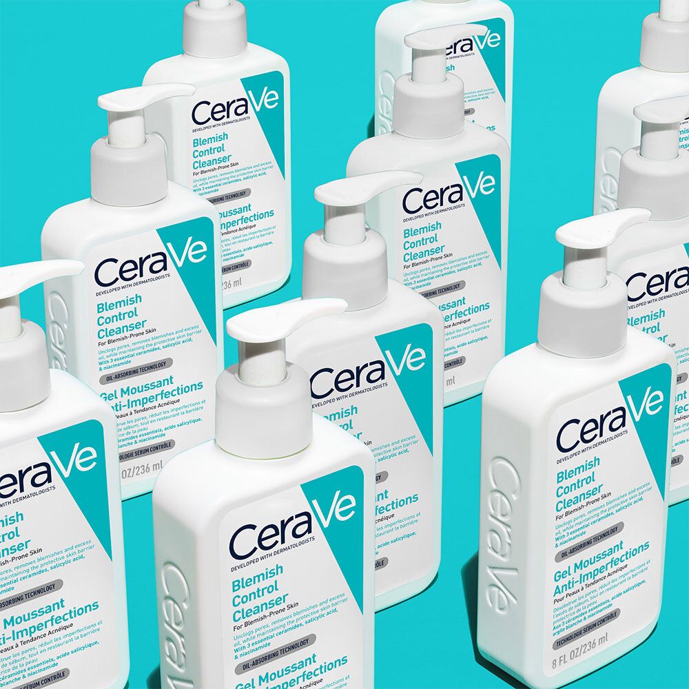 Plusieurs flacons blancs avec pompe. Inscription : CeraVe Blemish Control Cleanser. Fond turquoise.