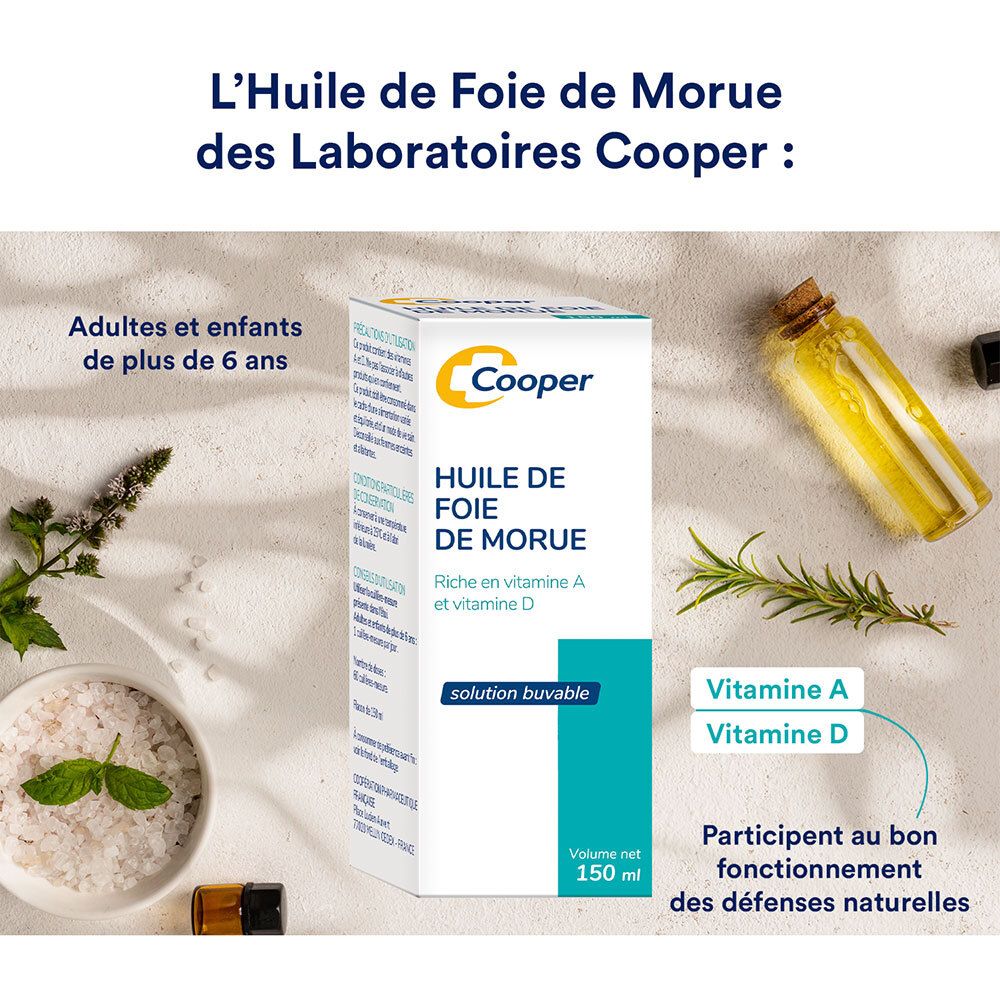 Emballage du produit avec nom et indication de vitamines. Sur une table avec herbes et flacons d'huile.
