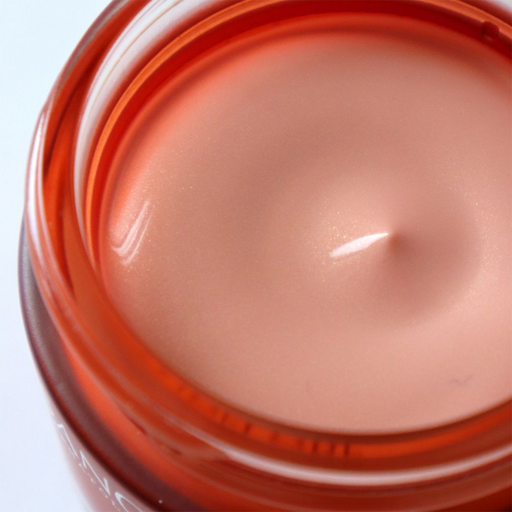 Gros plan sur le produit. Crème rose dans un pot rouge.