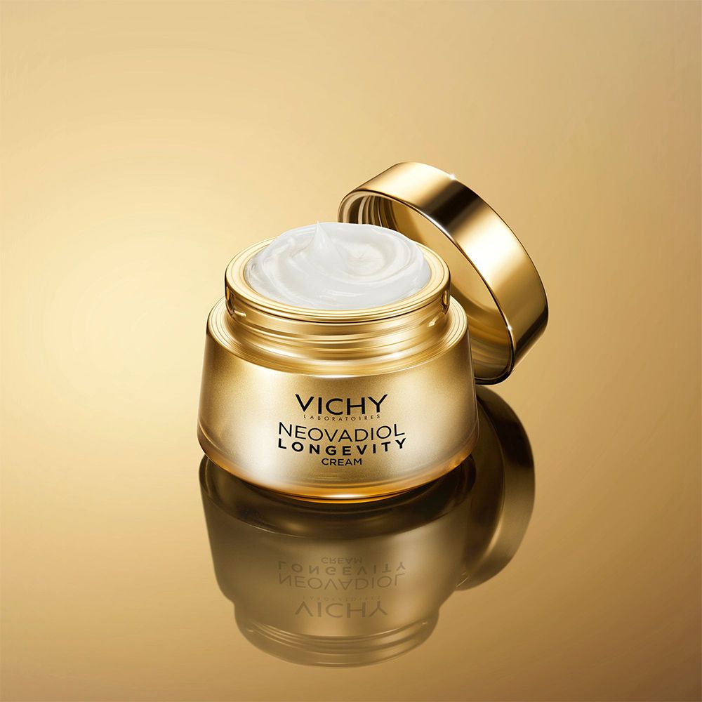 Pot doré ouvert. Inscription: VICHY, NEOVADIOL LONGEVITY CREAM. Crème visible.