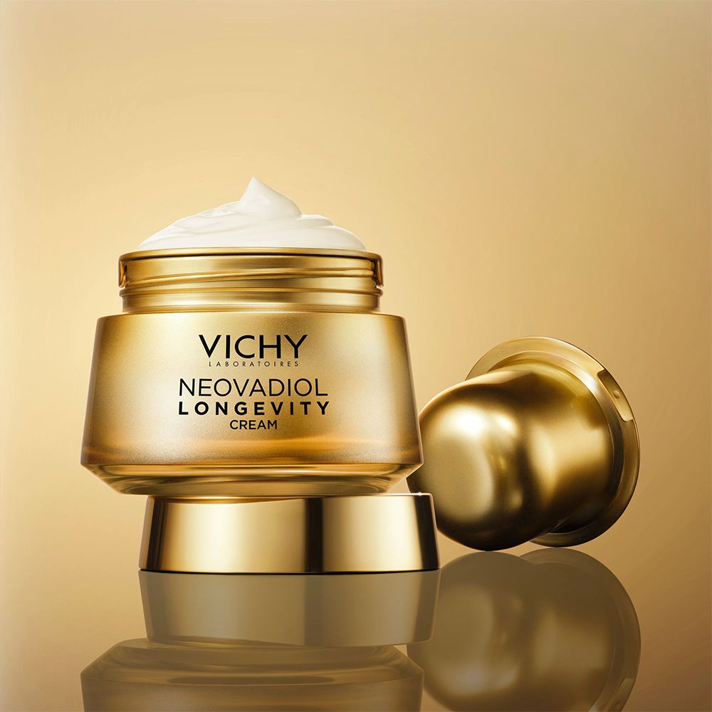 Pot doré avec crème et couvercle. Nom du produit et marque visibles.