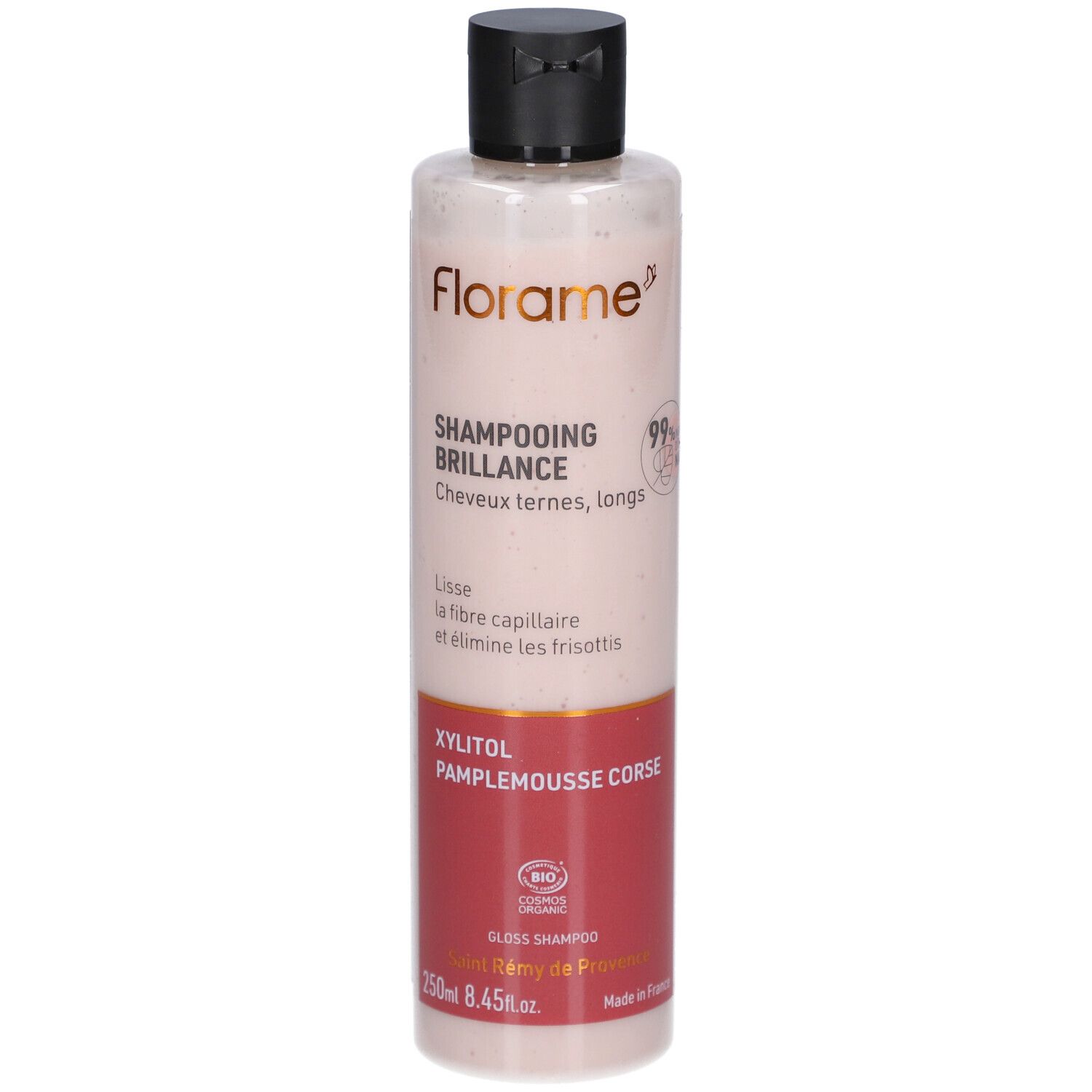 Flacon Shampooing Brillance. Liquide rose translucide. Bouchon noir. Zone d'étiquette rouge avec texte. Logo FLORAME.