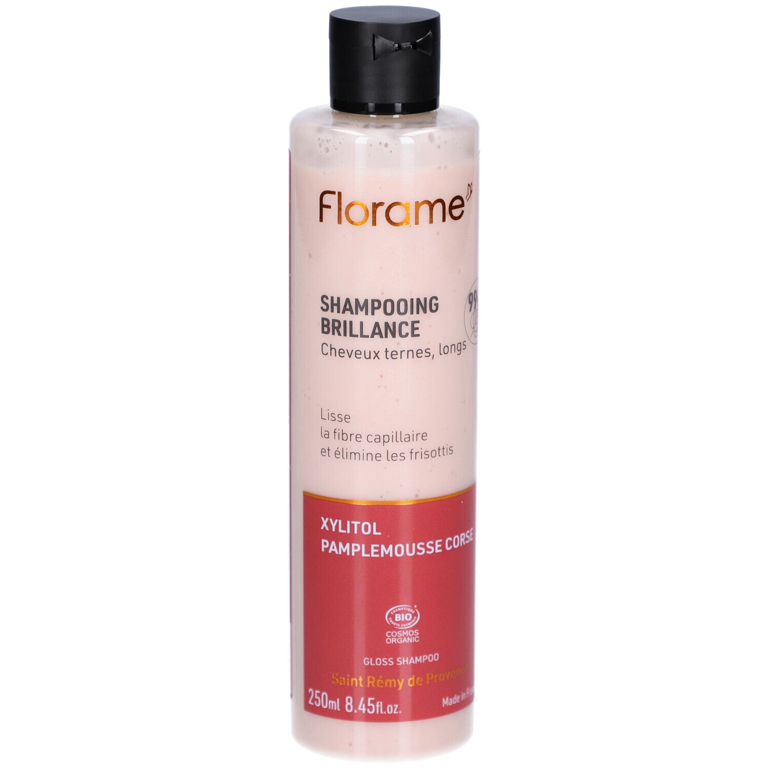 Flacon Shampooing Brillance. Liquide rose translucide. Bouchon noir. Zone d'étiquette rouge avec texte. Logo FLORAME.