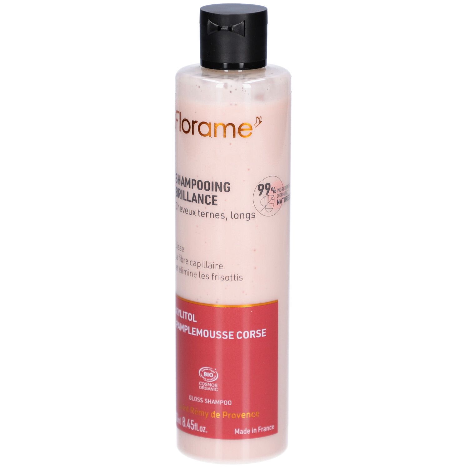 Flacon Shampooing Brillance. Liquide rose translucide. Bouchon noir. Zone d'étiquette rouge avec texte. Logo FLORAME.