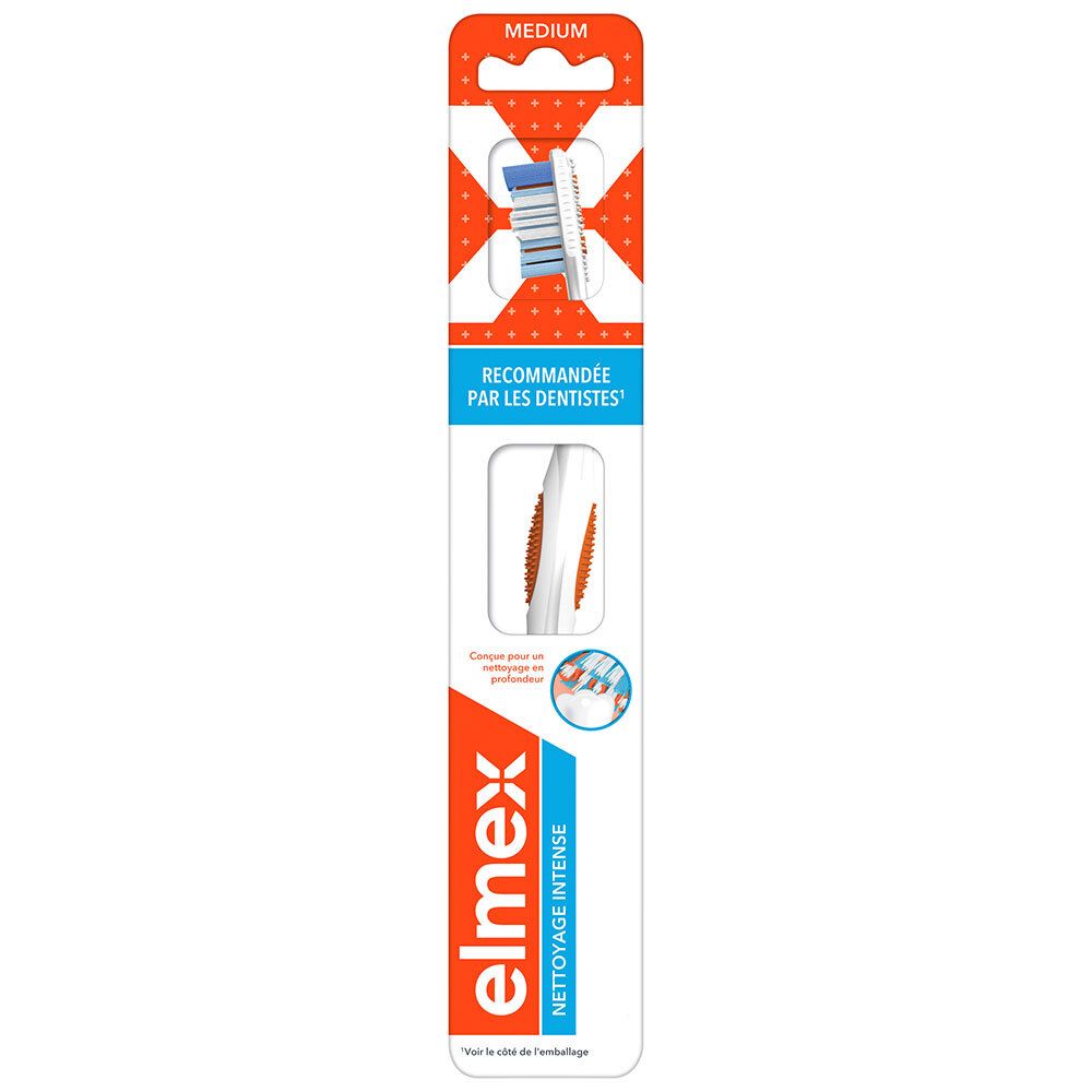 Brosse à dents dans son emballage. Design orange et blanc. Logo "ELMEX". Texte "RECOMMANDÉE PAR LES DENTISTES". Indication "MEDIUM".