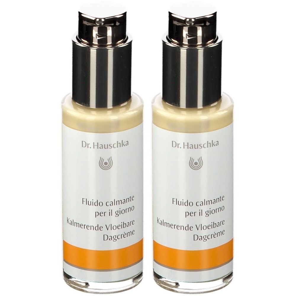 Deux flacons de Dr. Hauschka Fluide de Jour Apaisant. Étiquettes blanches avec nom et logo. Pompes argentées.