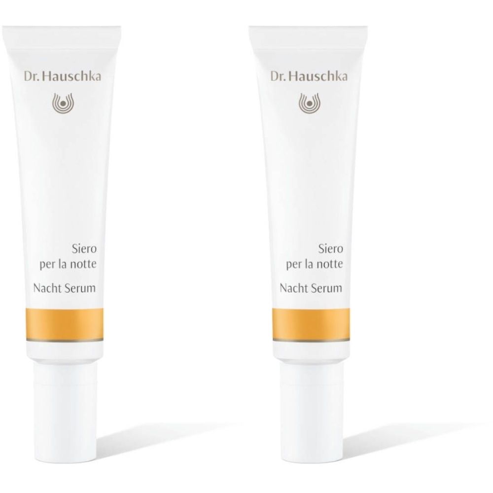 Deux tubes de sérum de nuit Dr. Hauschka. Tubes blancs avec section dorée et bouchon blanc. Texte : Siero per la notte, Nacht Serum.
