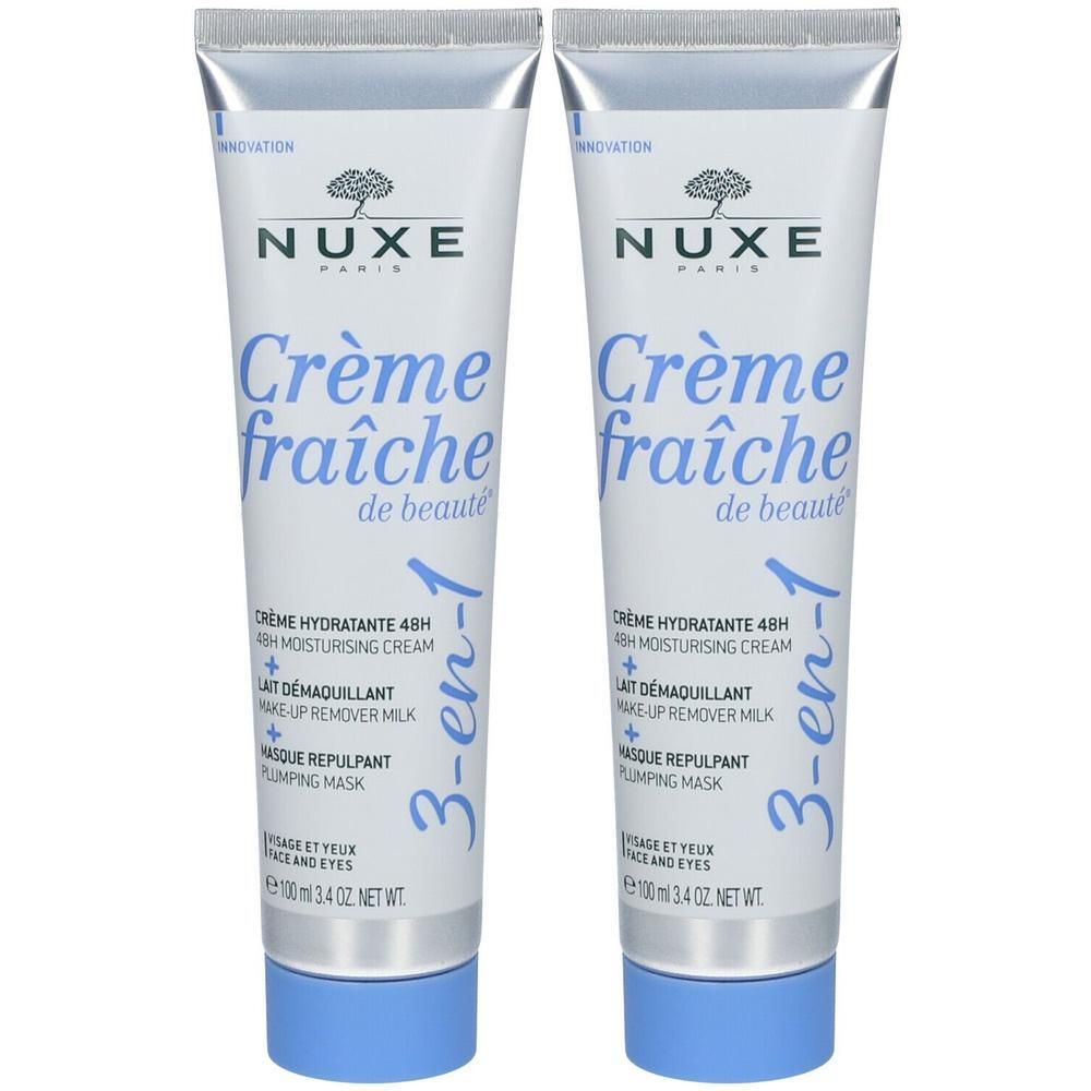 Deux tubes de Nuxe Crème Fraîche de Beauté 3-en-1. Tubes blancs avec bouchons bleus. Inscription: Nuxe, Crème fraîche de beauté.