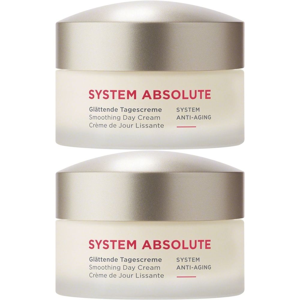 Deux pots de crème avec couvercles argentés. Inscription : SYSTEM ABSOLUTE, Glättende Tagescreme, Smoothing Day Cream, Crème de Jour Lissante, SYSTEM ANTI-AGING.