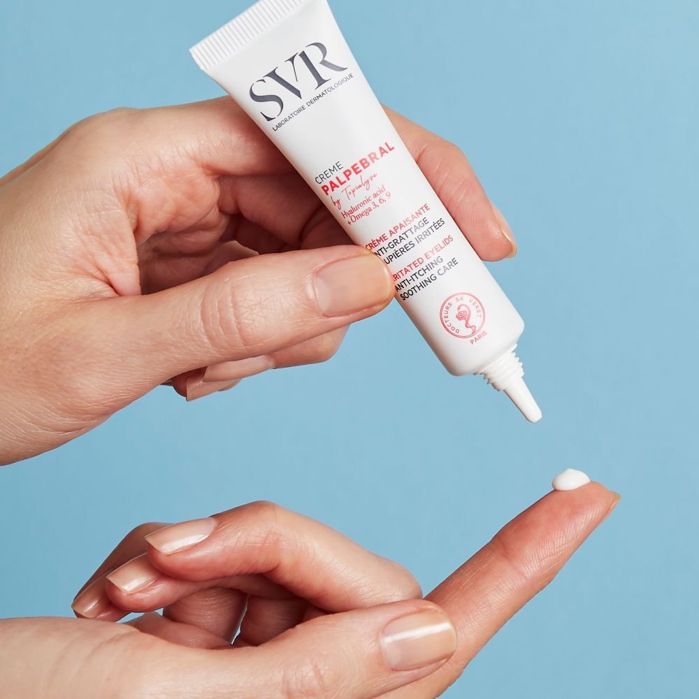 Un tube de crème pour les yeux est appliqué sur un doigt. Marque SVR, nom du produit CREME PALPEBRAL. Texte: Anti-démangeaisons, paupières irritées.