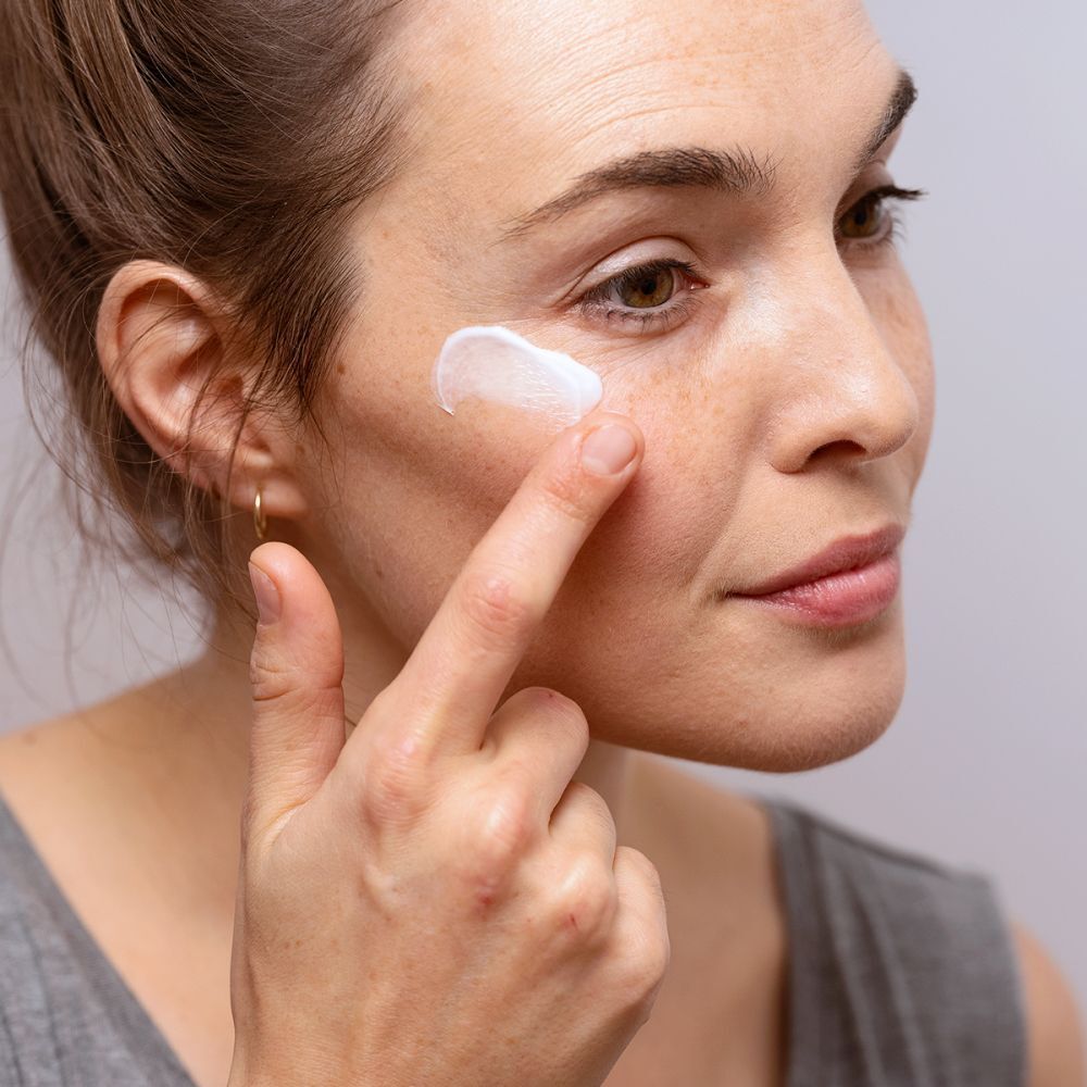 Femme appliquant de la crème pour les yeux. Marque SVR, nom du produit CREME PALPEBRAL. Texte: Anti-démangeaisons, paupières irritées.
