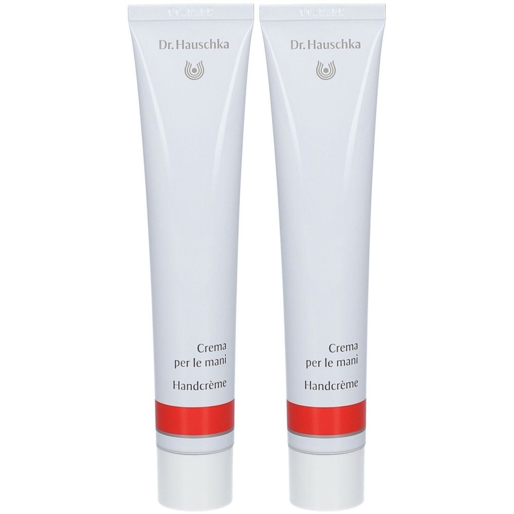 Deux tubes blancs avec une bande rouge. Inscription: Dr. Hauschka, Crème pour les Mains, Handcrème.