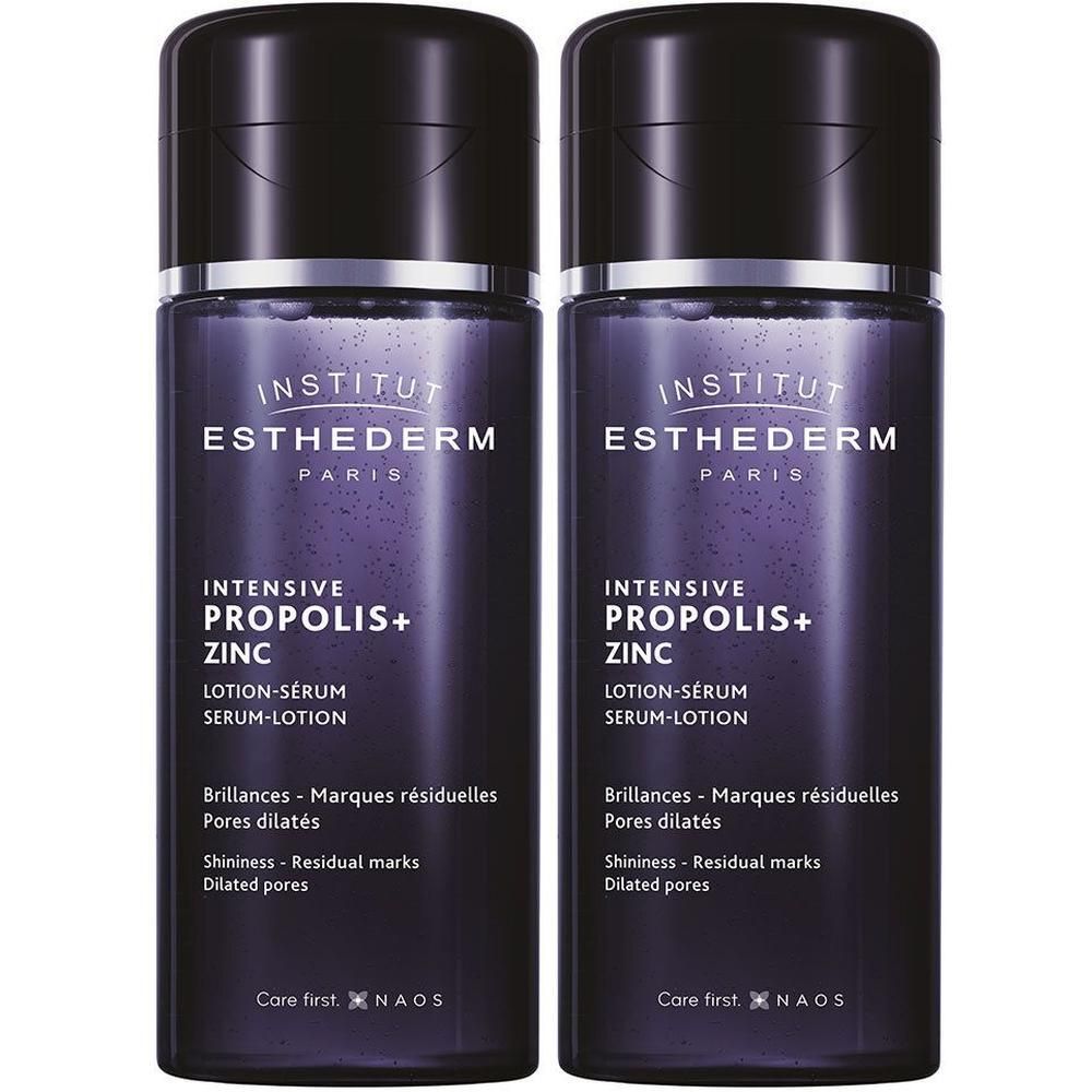 Deux flacons de lotion-sérum INSTITUT ESTHEDERM. Flacons violets foncés avec bouchons noirs. Nom du produit et texte visibles.