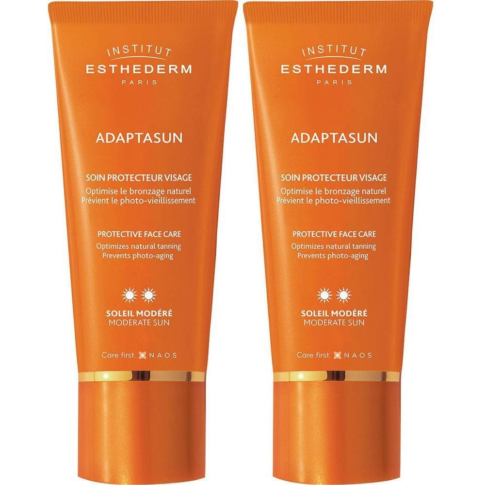 Deux tubes Adaptasun orange, texte et logo visibles. Soleil Modéré, Protective Face Care.