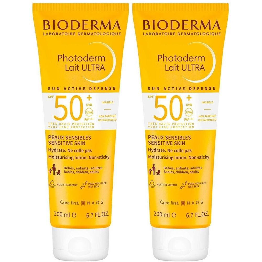Deux tubes de crème solaire. Emballage jaune avec bouchon blanc. Inscription: BIODERMA, Photoderm Lait ULTRA, SPF 50, peaux sensibles.