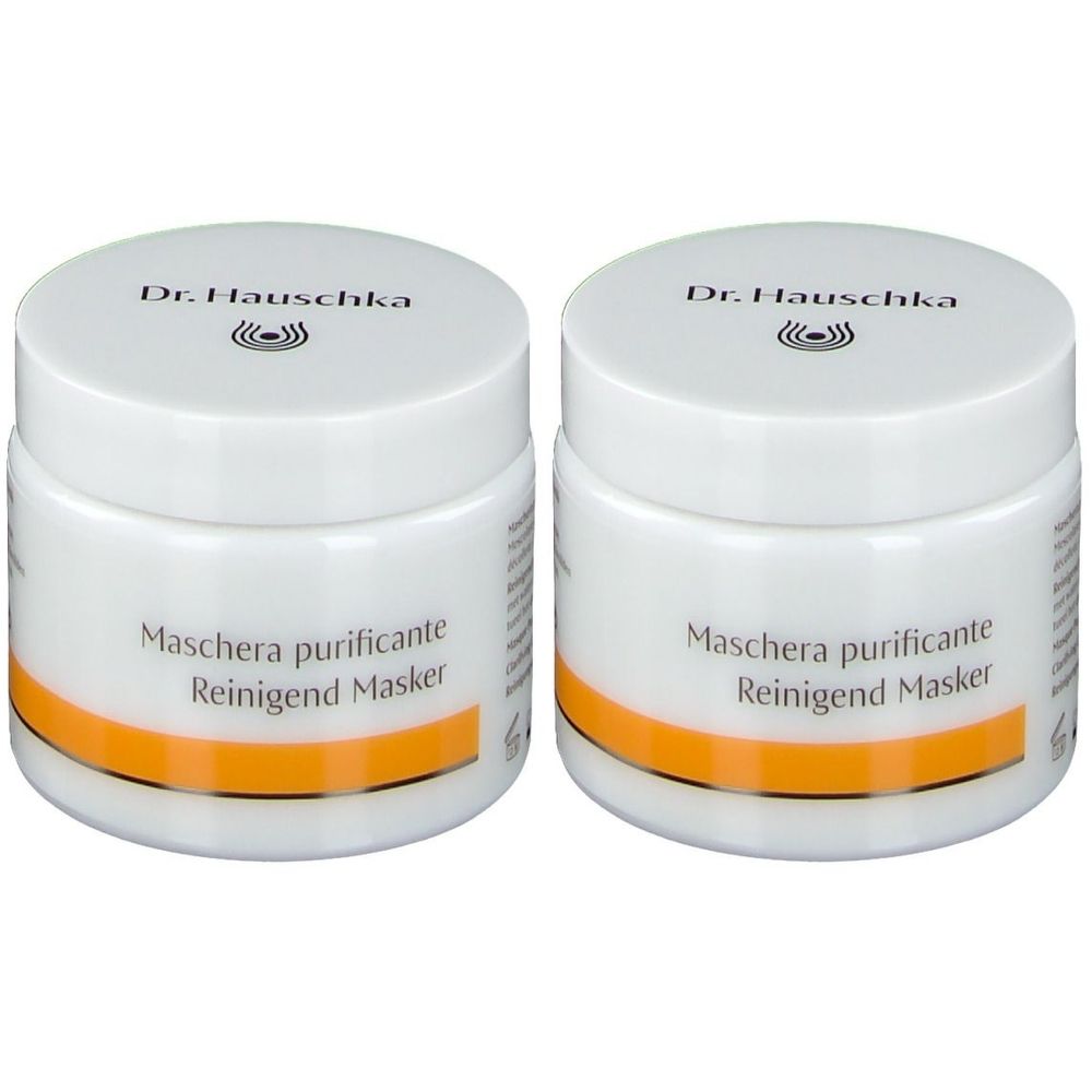 Deux pots blancs avec couvercles. Inscription: Dr. Hauschka, Maschera purificante, Reinigend Masker. Bande orange.