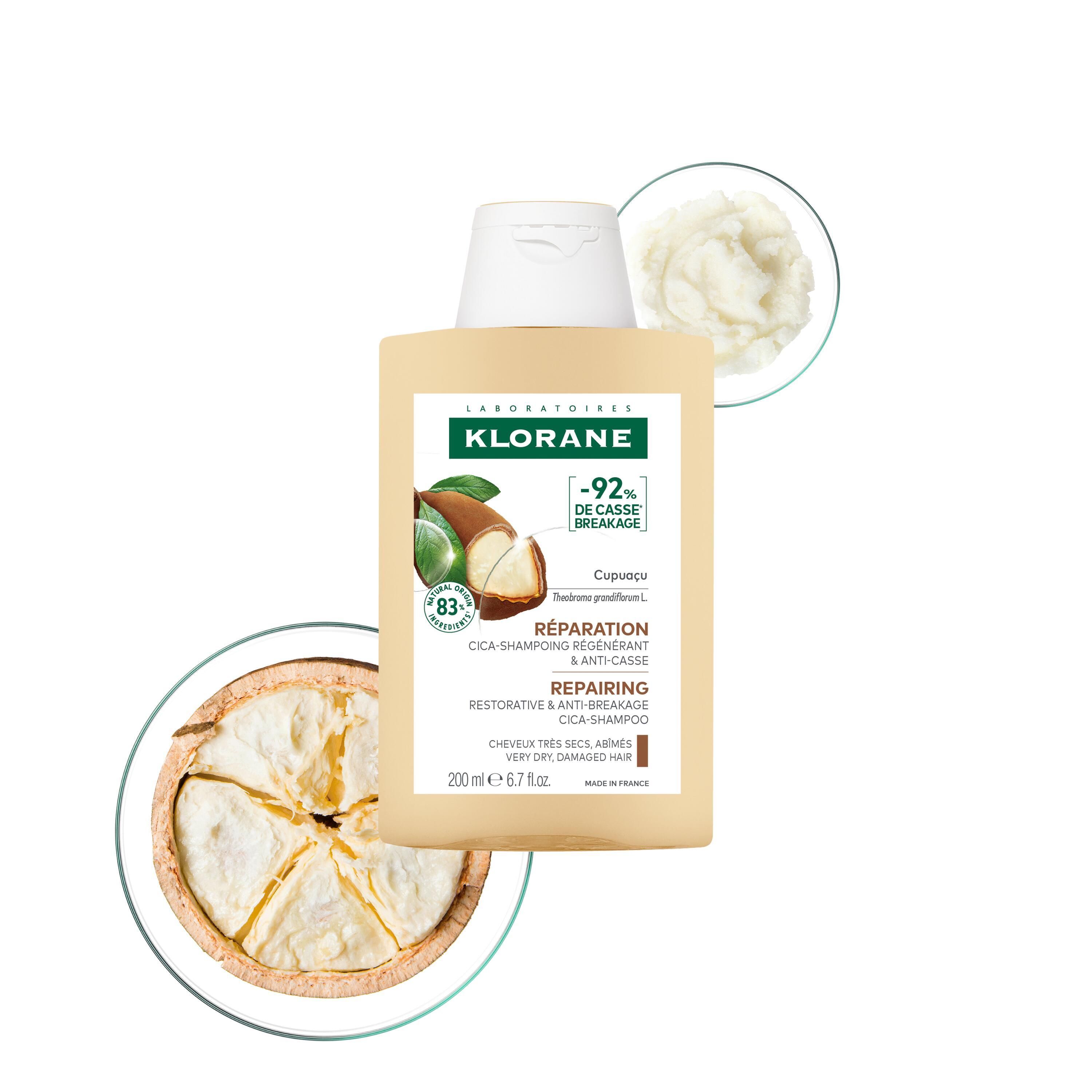 Flacon de shampooing beige à bouchon blanc. Illustration de fruit et beurre de cupuaçu. Texte : Klorane, réparation, anti-casse.