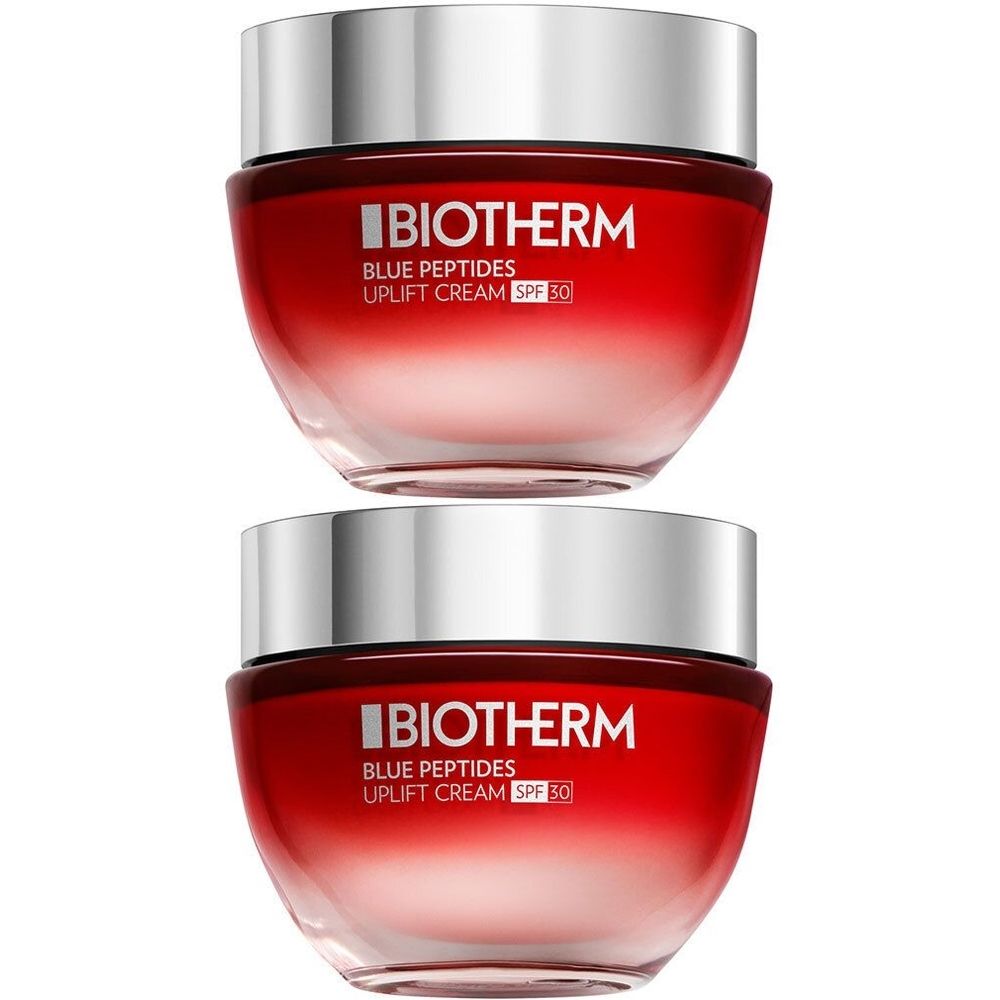 Deux pots de crème Biotherm Blue Peptides Uplift SPF 30. Dégradé de rouge, couvercle argenté. Inscription : BIOTHERM.