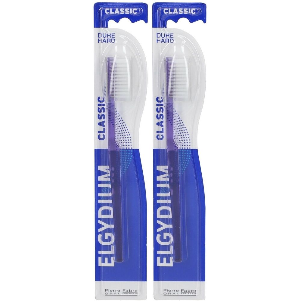 Deux brosses à dents emballées. Manches bleus, soies blanches, accents violets. Inscriptions: ELGYDIUM, CLASSIC, DURE HARD.