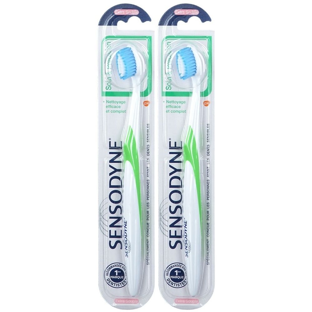 Deux brosses à dents Sensodyne emballées. Manches blancs, accents verts. Têtes bleues. Emballage plastique transparent.