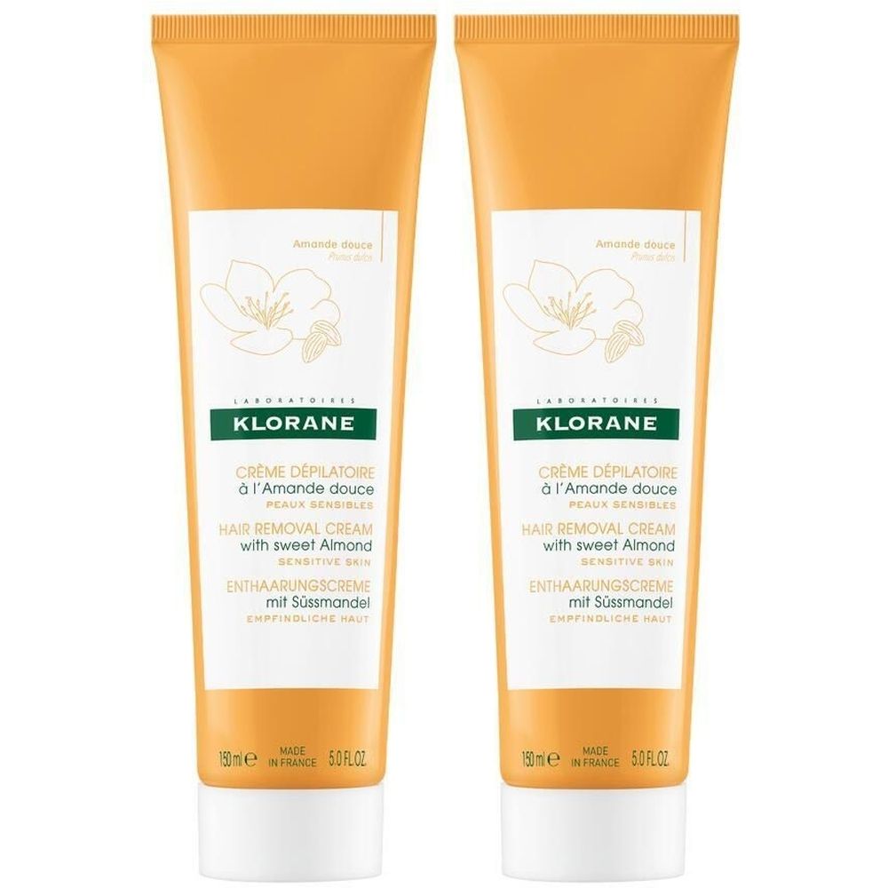 Deux tubes de crème dépilatoire KLORANE à l'amande douce. Tubes orange avec étiquette blanche et informations produit.