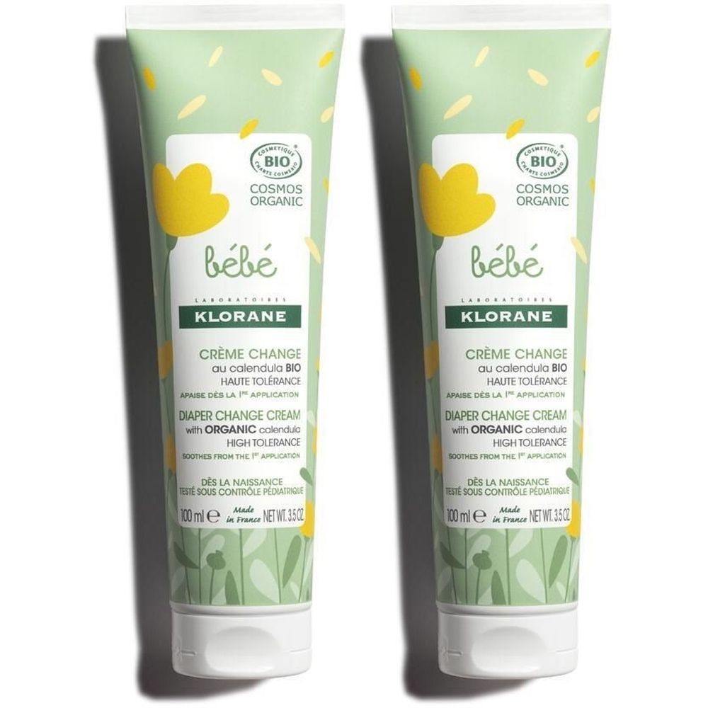 Deux tubes de crème pour bébé. Design vert et blanc avec des fleurs jaunes. Inscription : Crème Change, Haute Tolérance.