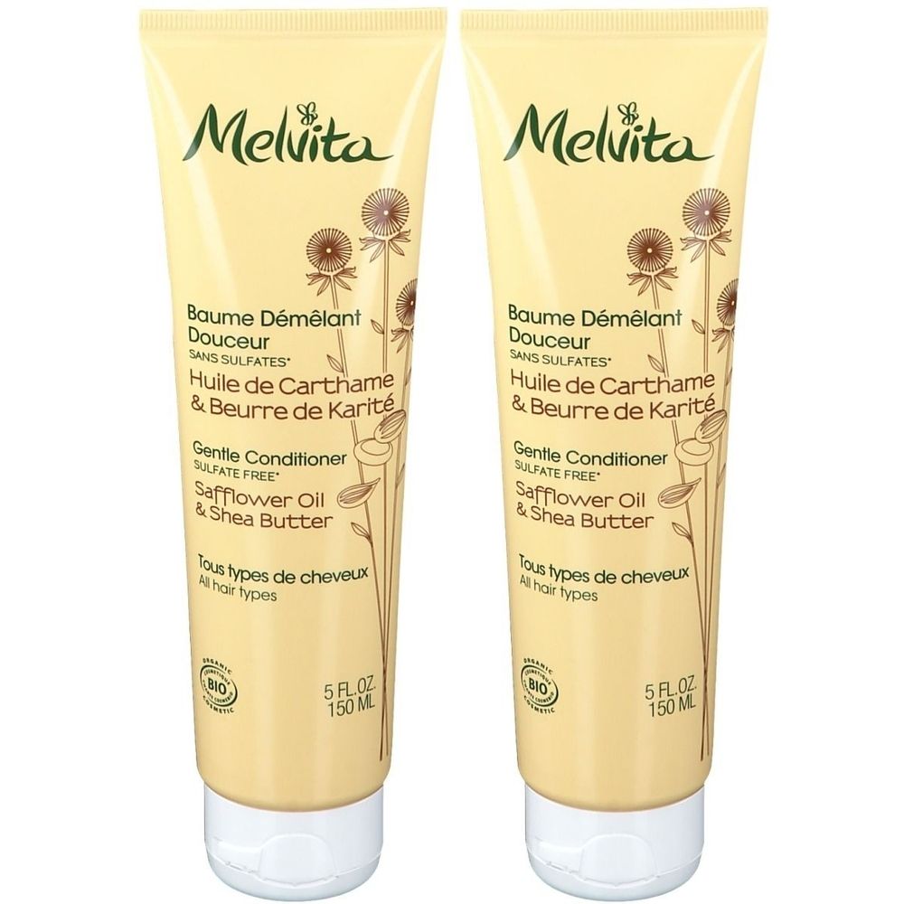 Deux tubes de Baume Démêlant Melvita. Tubes beiges avec bouchon blanc. Inscription : Baume Démêlant Douceur, Safflower Oil & Shea Butter.